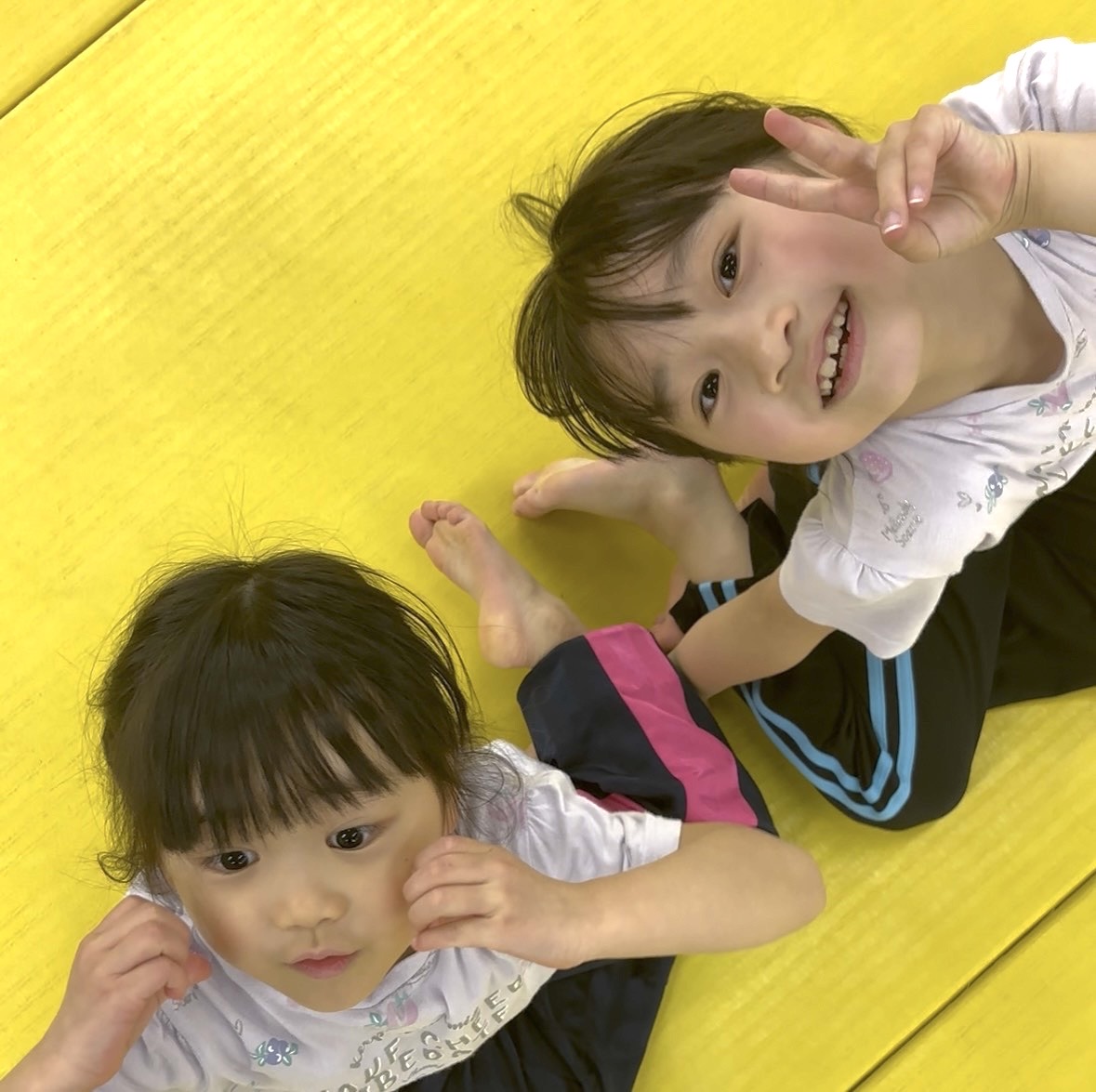マットで笑顔の子どもたち